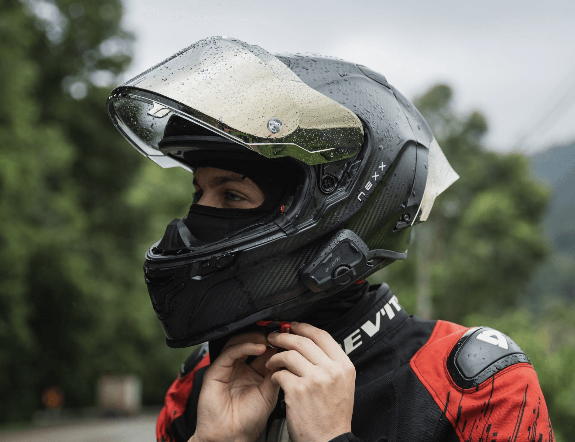 Rider wearing a helmet with the Cardo Freecom 4X mounted, giving a thumbs up